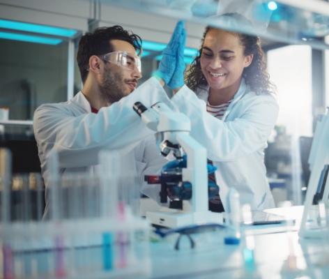 two scientists high fiving in lab doing experiments