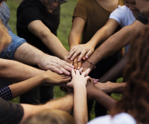 many hands coming together in one pile